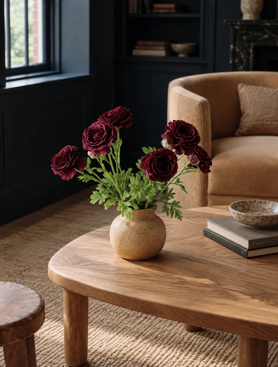 Burgundy flowers in a ceramic vase on a wooden coffee table